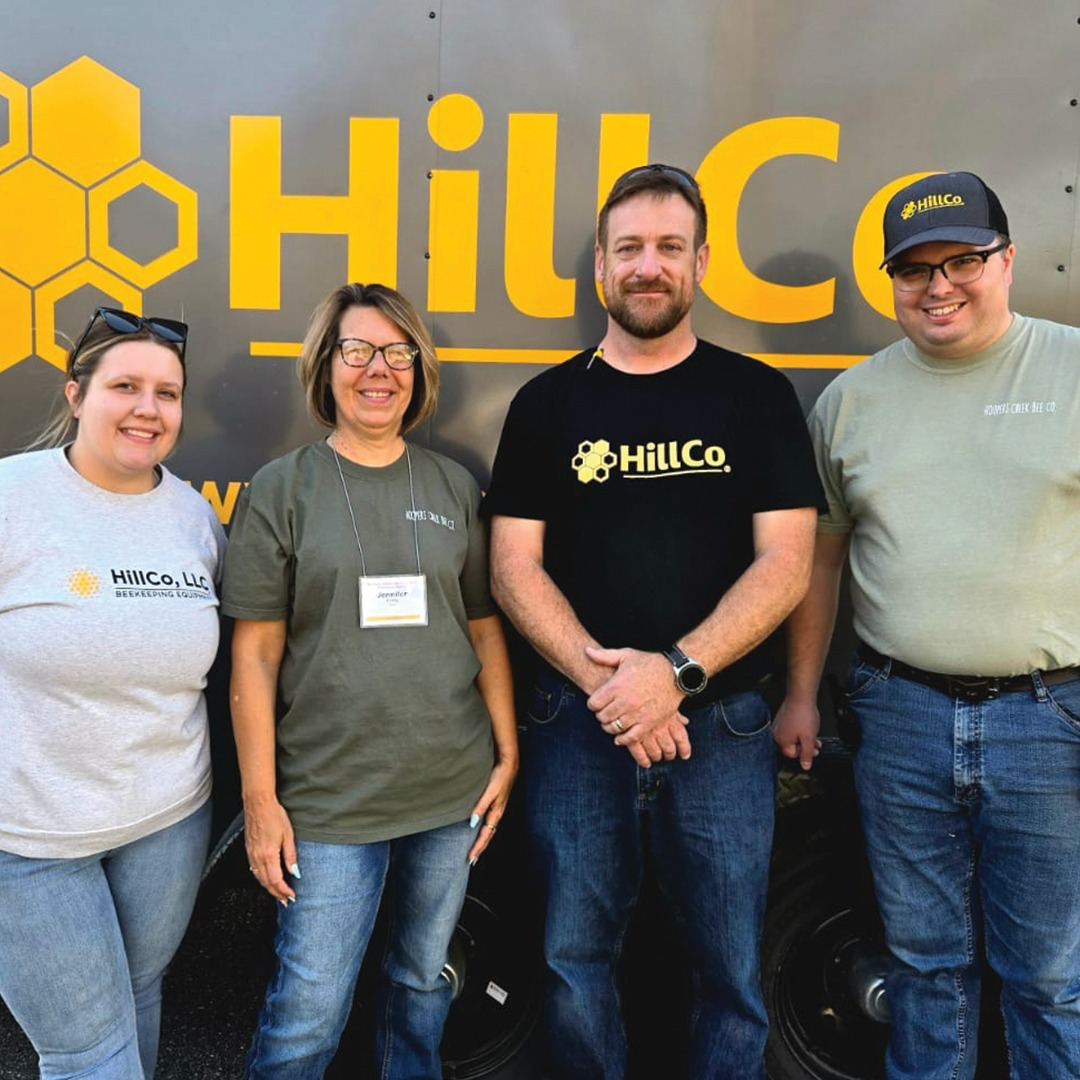 Four people standing in front of a HillCo branded background
